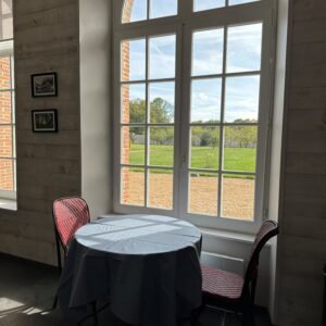 Table de déjeuner devant la grande fenêtre du gîte de L'Orangerie