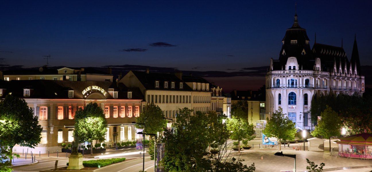 Façade de l'Hotel du Grand Monarque éclairée de nuit.