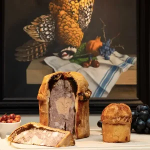 Pâté de Chartres découpé devant une nature morte sur le thème de la chasse